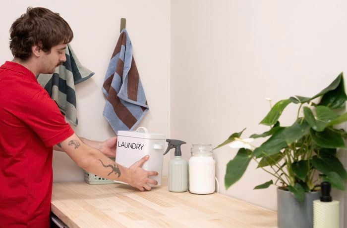 Style the laundry benchtop with storage containers, detergent and indoor plant