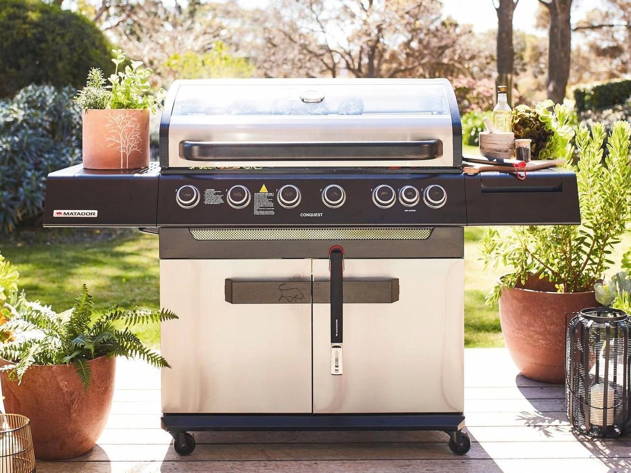 Stainless steel barbecue in a garden setting.