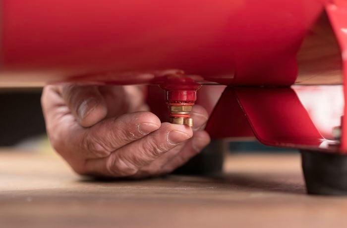 Person draining the air compressor valve