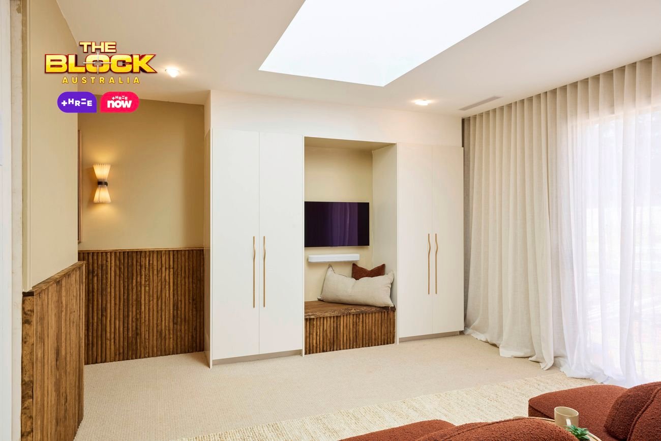 Cozy lounge area with built-in seating, TV, and soft neutral decor