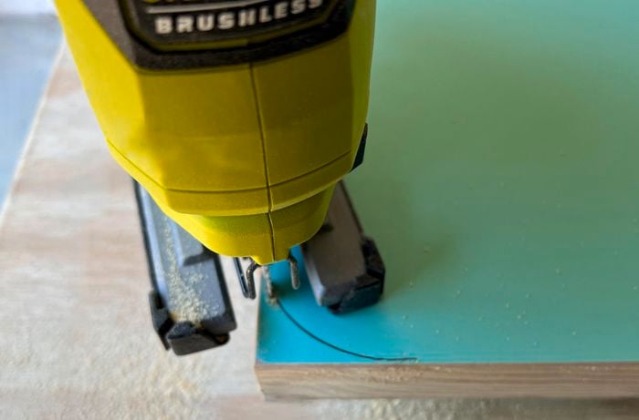 Close up of a jigsaw cutting a door panel to create rounded corners.