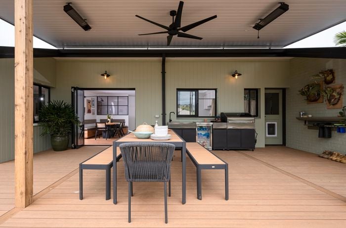 Outdoor entertaining area with a table and chairs in it and timber flooring