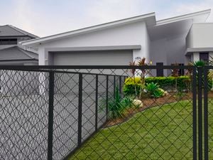 Black wire grid fence at the front of a house