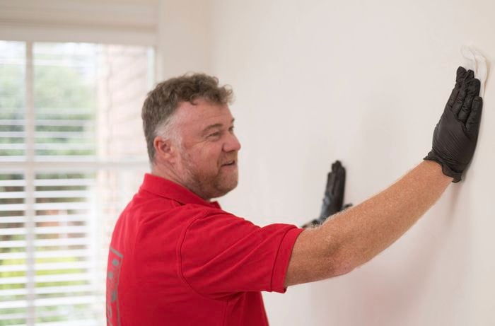 Cleaning the walls with sugar soap wipes.