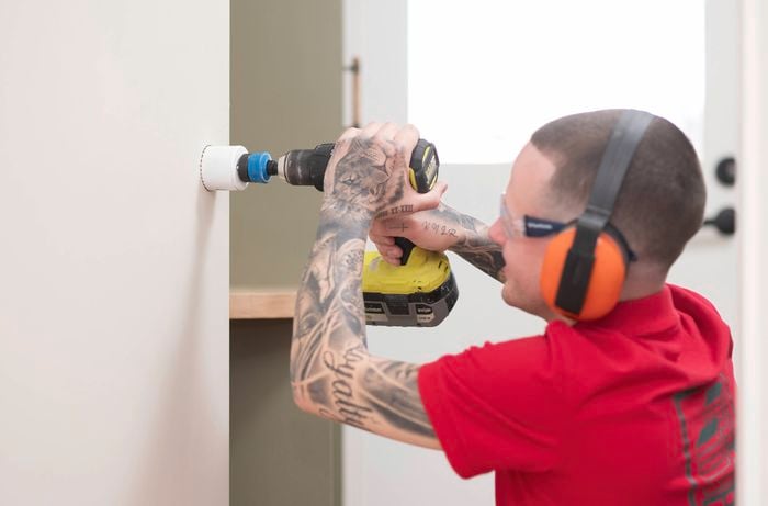 Drill a hole with hole saw attachment in the wall