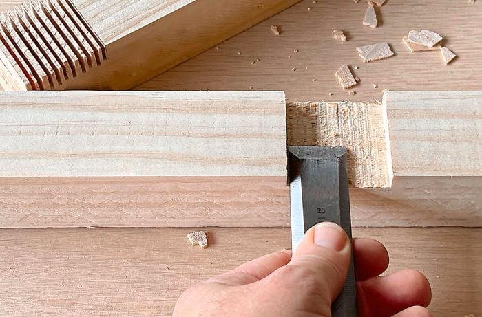 Person chisels into a piece of pine.