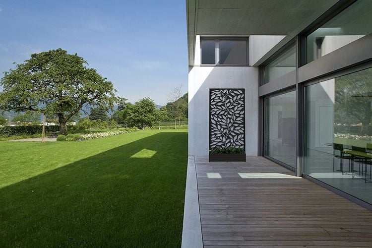 Backyard of home with large grass area and timber deck