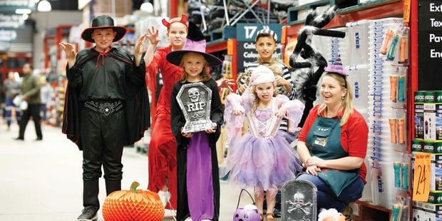 image of a store with team members and kids dressed in halloween costumes