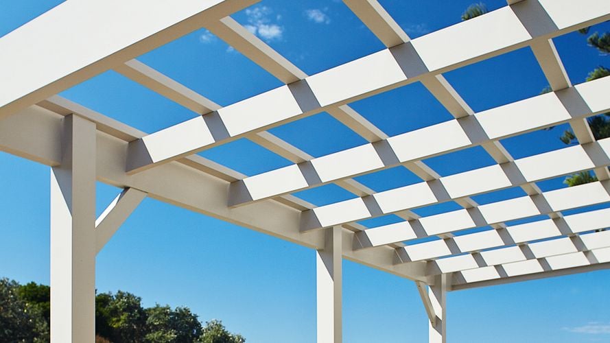 View of a white painted pergola looking upwards to blue sky