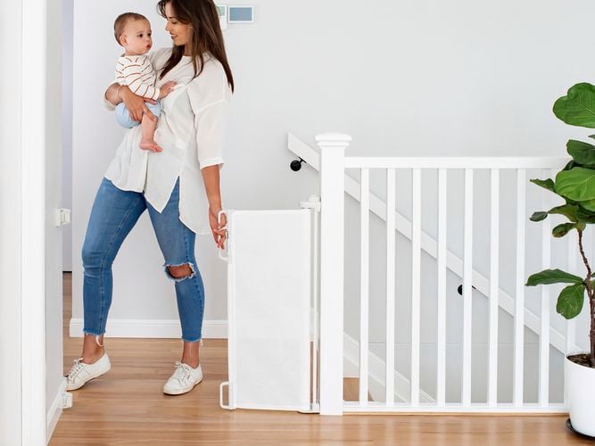 a woman with a  kid near retractable child gate