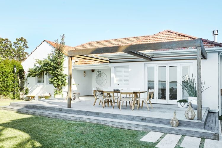 Front view of a white period home with timber pergola, deck and outdoor furniture