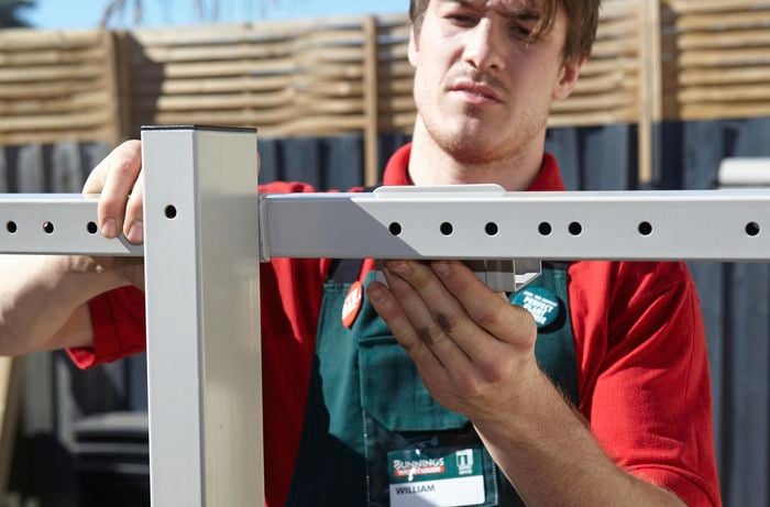 A Bunnings team member attaching the hooks to the universal bracket.
