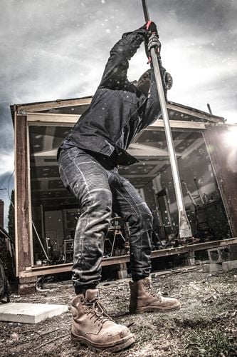 A tradesman driving a stake into the ground
