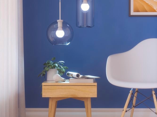 Smart LED light bulbs in a lighting fixture over a coffee table.