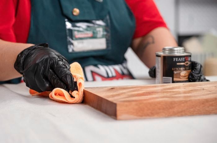 Applying food-grade sealant using a cloth.