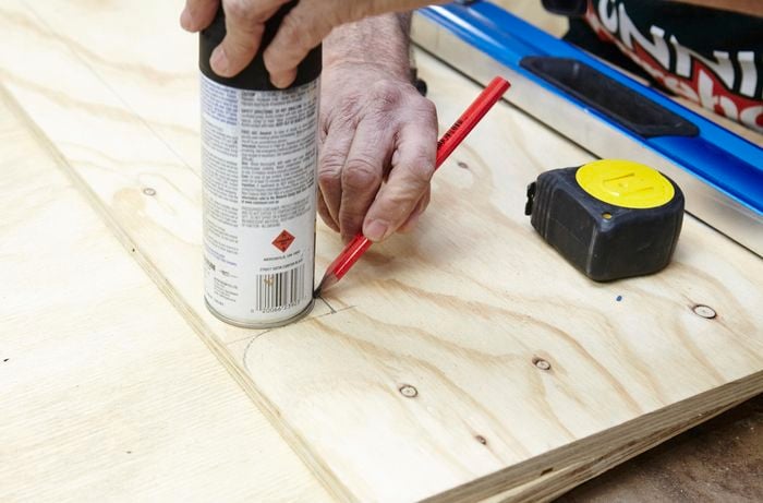 Person tracing can on ply panel to mark circular cuts