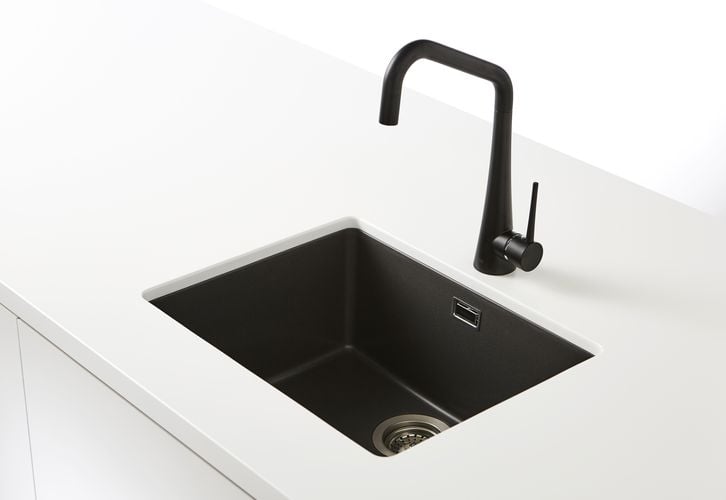 White kitchen benchtop with black sink and tapware
