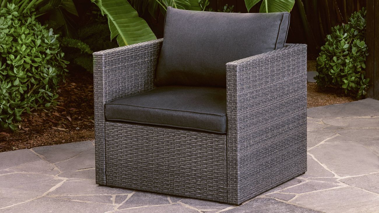 Grey wicker outdoor armchair with dark cushions