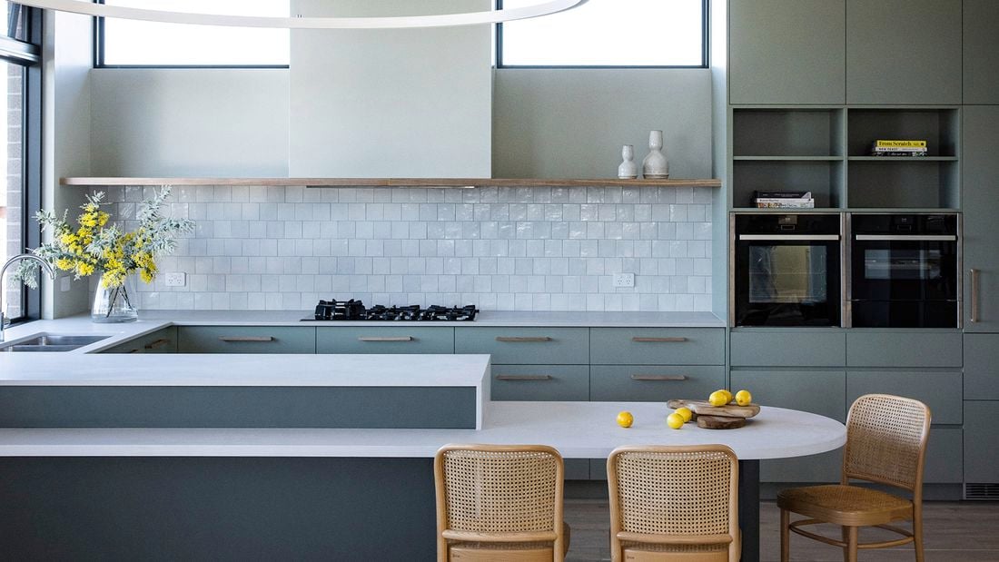 A kitchen showcasing assisted living design with comfortable seats for food prep and accessible oven and microwave