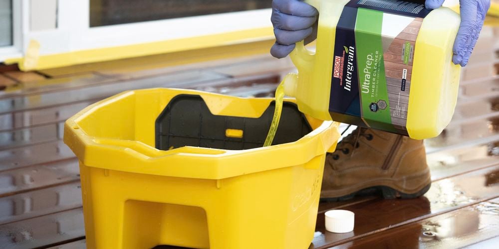 Person pouring ultraprep into a decking applicator bucket