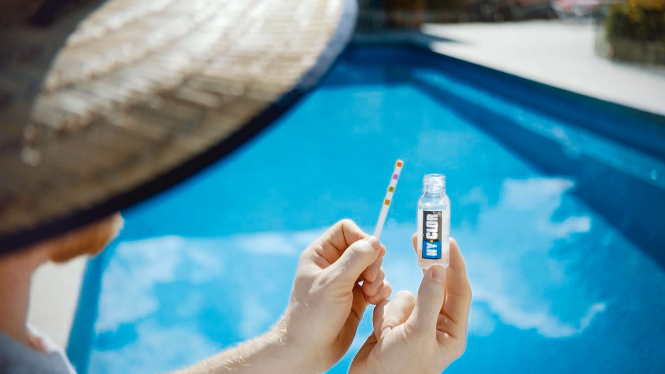Man testing the water of his pool with Hy-Clor products