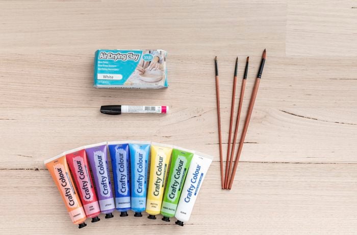 Topdown view of a packet of putty, paintbrushes and a variety of paints