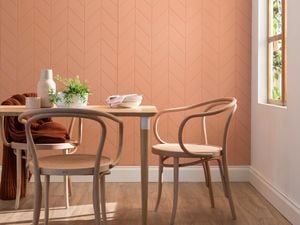 Breakfast table and chairs in a light filled room with apricot colour panelled walls
