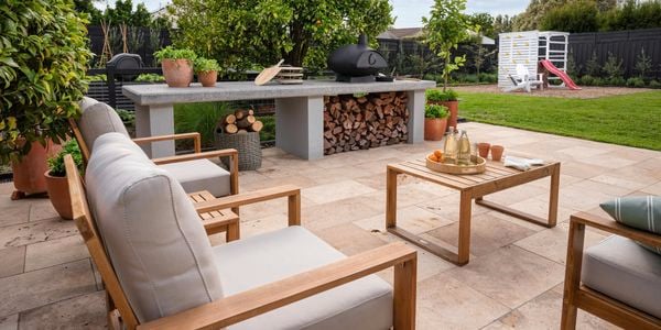 Alfresco and backyard area with outdoor furniture, marble benchtop with pizza oven and outdoor play area.