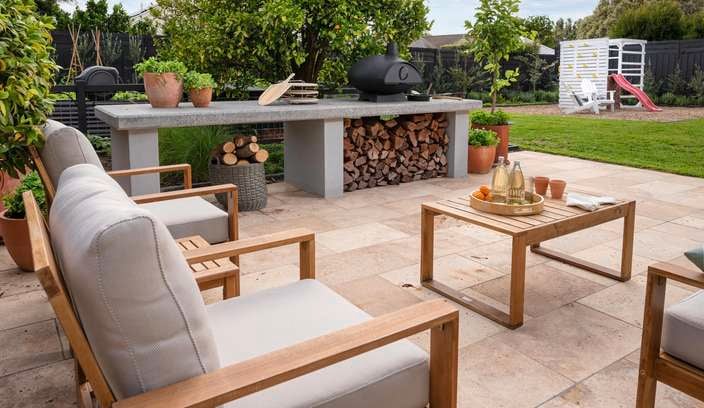 Alfresco and backyard area with outdoor furniture, marble benchtop with pizza oven and outdoor play area.