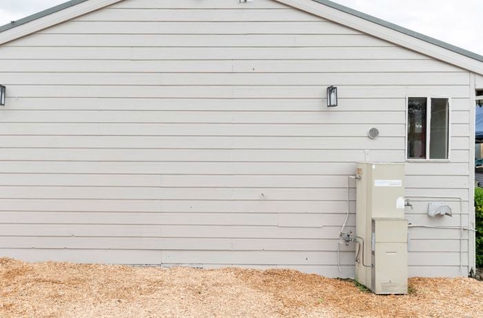 Large blank end wall of a white weatherboard house