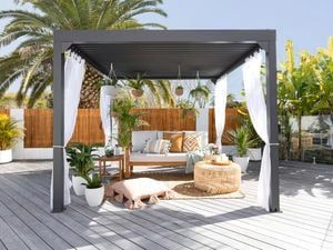 Outdoor gazebo styled with cushions, couch, hanging baskets and sheer curtains.