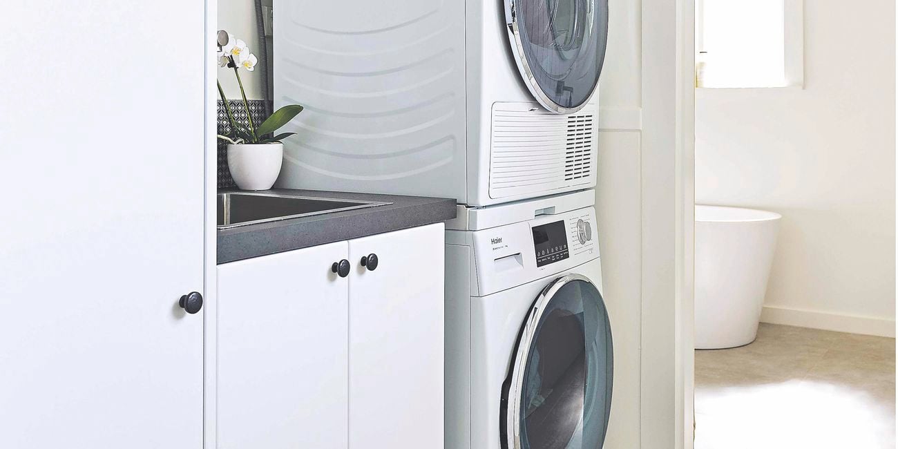 Stacked washer and dryer next to sink