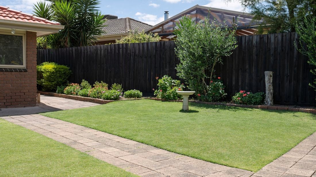 Front garden with added garden beds with shrubs and couch grass.