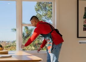 A person opening up a window.