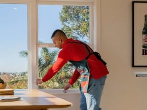 A person opening up a window.