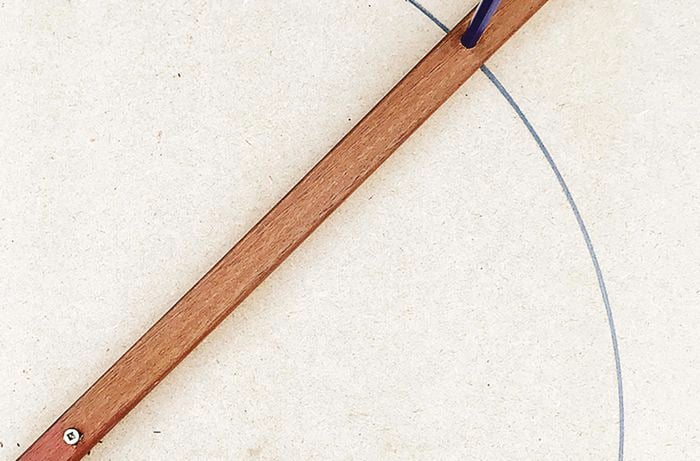 A circle marked on MDF board using a pencil fitted to a pine.
