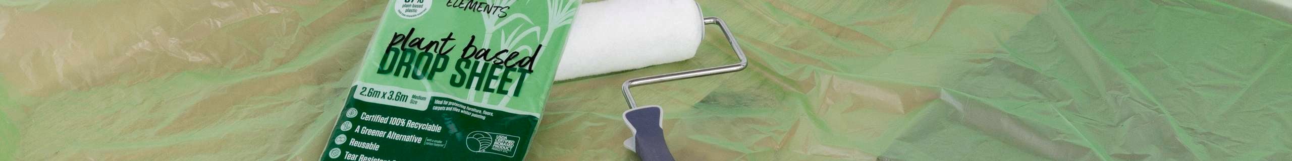 Green drop sheet covers the ground with unwrapped plant-based drop sheet and paint roller lying on top.