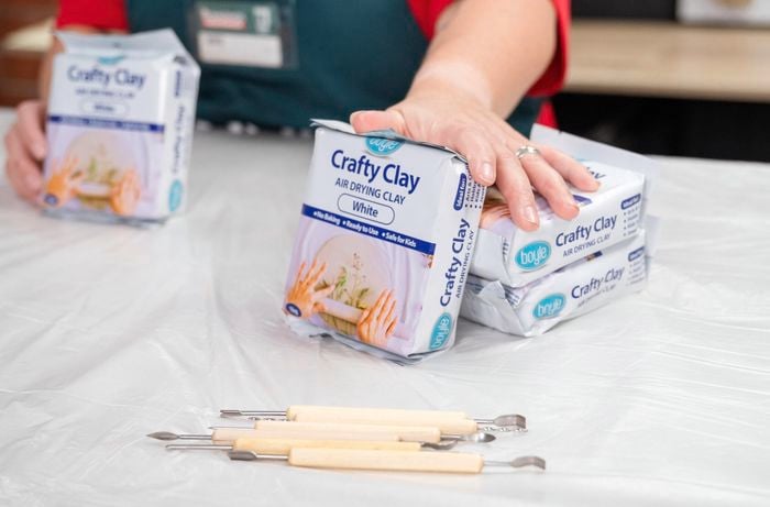 A person showing clay products and tools.