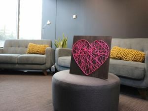 String art heart picture on an ottoman in a living room
