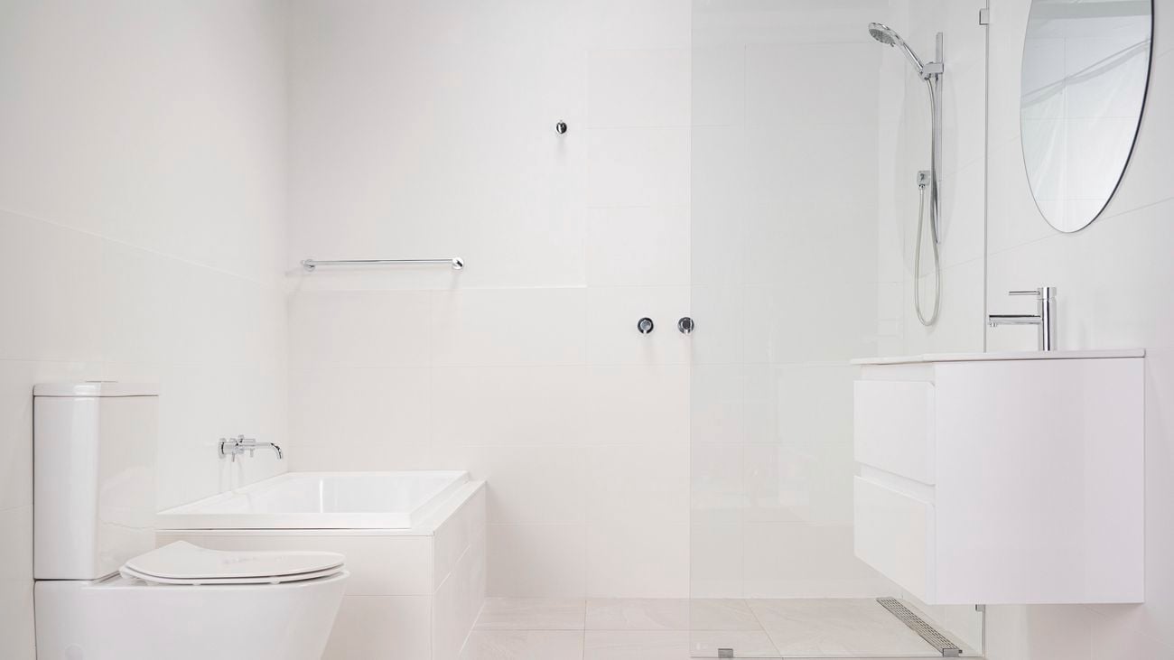 Bathroom with everything in white colour and stainless steel fittings. 