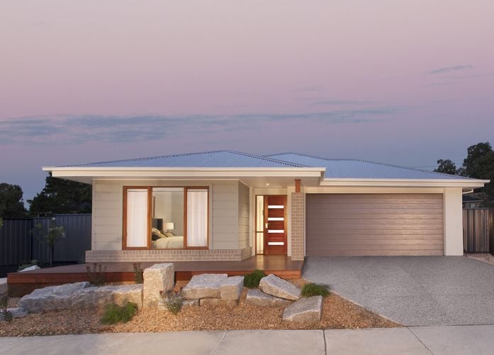 The facade of a modern home with timber trim on the windows and doors