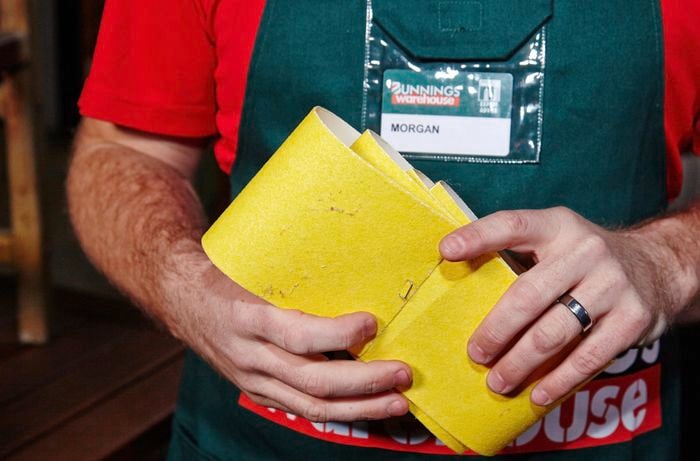 A person holding several rolls of sandpaper