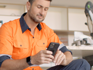 Tradie person with orange Fluro shirt looking at this phone.