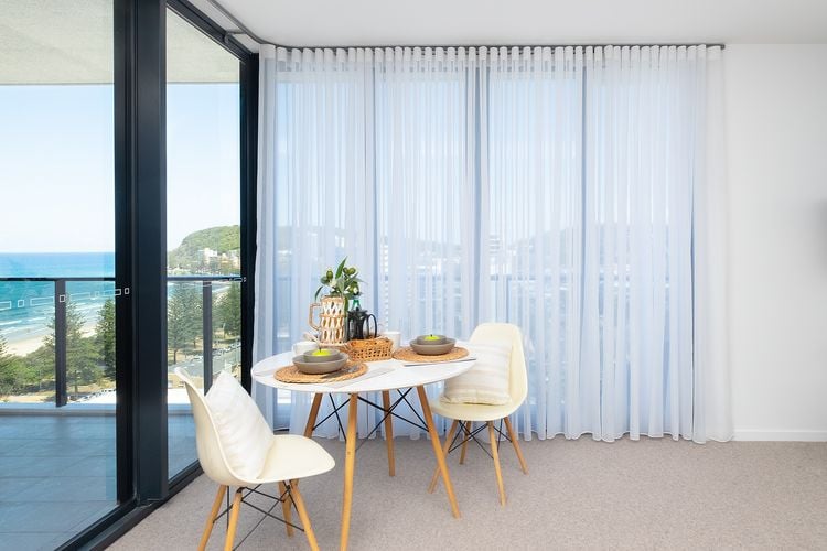 Seaside apartment with sheer curtains covering windows