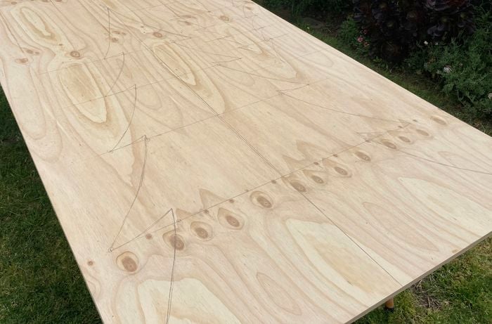 Christmas tree drawn out on a piece of plywood.