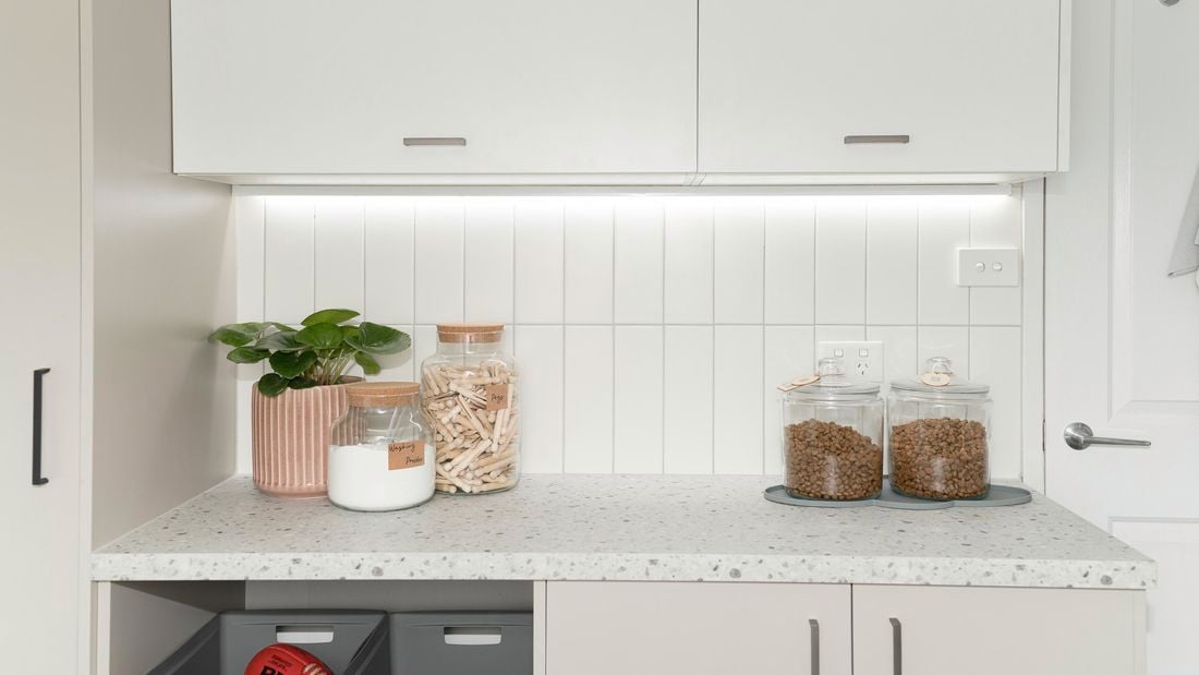 Laundry with cabinets, basket pull outs and decorative items.