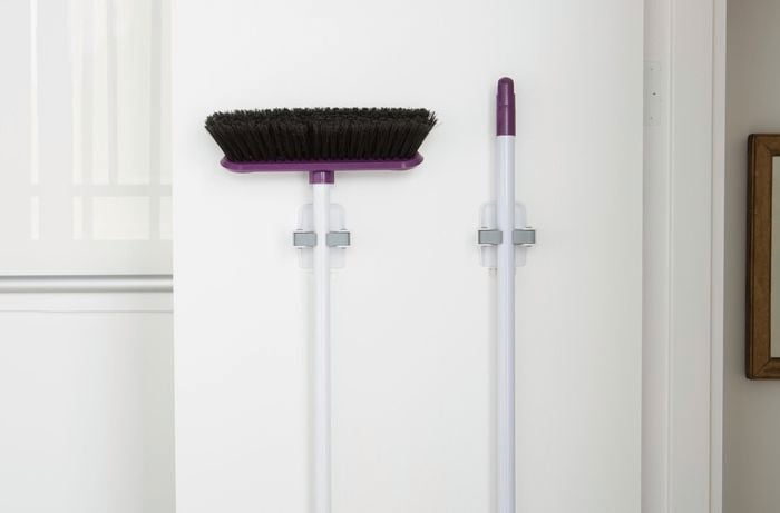 Broom hanging on a wall-mounted clip