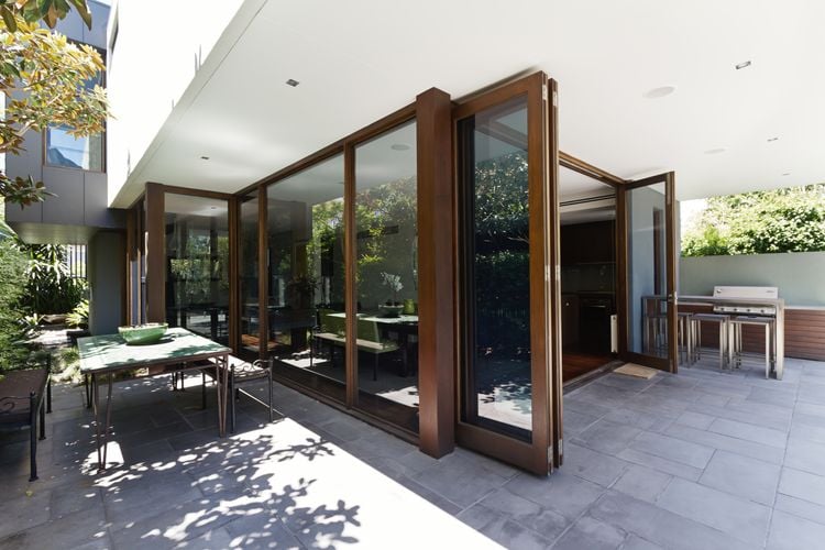 Wooden and glass bay doors leading to an outdoor dining area