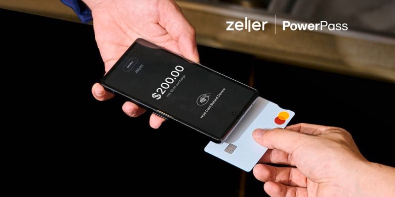 A person holding a card to a smart phone to make payment