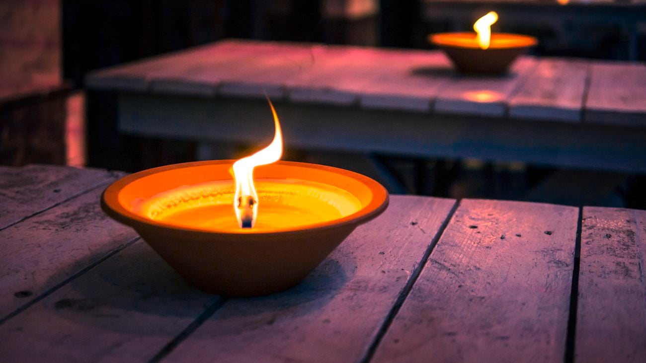 Citronella candles burning on outdoor table in the evening